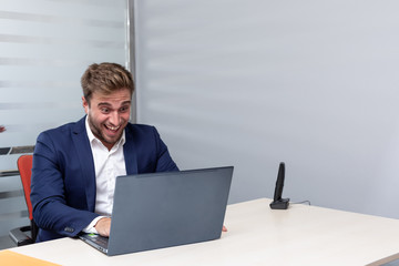 
euphoric young business man working on laptop