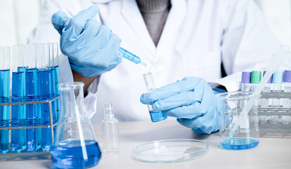 Fototapeta premium Doctors use a syringe to absorb vaccines, blue chemical liquid for research and analysis in a laboratory, to try and treat bacterial viruses
