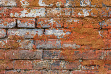 Old, antique wall of red destroyed bricks. The brickwork is made of bricks produced according to the old technology.