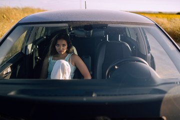 Retratos de una chica joven y guapa en un coche