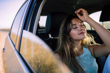 Retratos de una chica joven y guapa en un coche