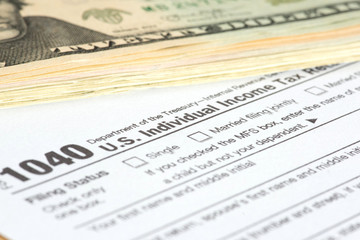 Dollar Banknoten und Formular 1040 für die Steuererklärung