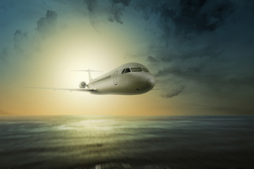 Obraz na płótnie Canvas Airplane flying in the air above the ocean