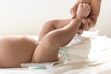 赤ちゃんの紙おむつを交換している男性の手