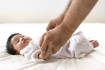 赤ちゃんと手をつなぐ男性の手