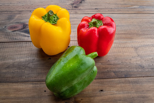 sweet pepper on wood background, paprika, red, green and yellow sweet bell peppers on table
