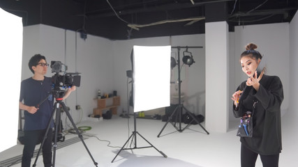 撮影スタジオでセミナーの動画を撮るカメラマンと講師