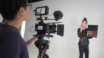 撮影スタジオでセミナーの動画を撮るカメラマンと講師