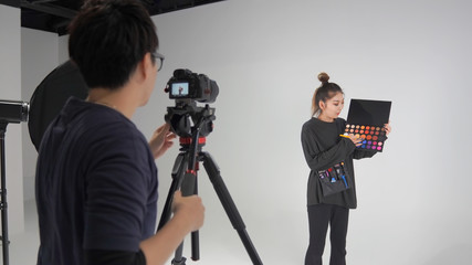 撮影スタジオで動画を撮る動画カメラマンと被写体
