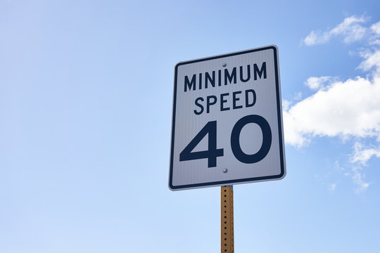 40 mph minimum speed sign on a highway to keep a smooth traffic flow. Speed zone traffic sign against blue sky and clouds.