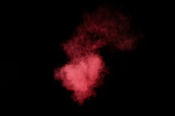 Red and pink powder explosion on black background. Colored powder cloud. Colorful dust explode. Paint Holi.