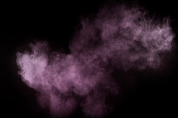 Purple powder explosion on black background. Colored powder cloud. Colorful dust explode. Paint Holi.