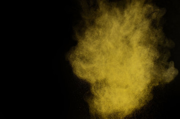 Yellow powder explosion on black background. Colored powder cloud. Colorful dust explode. Paint  Holi.