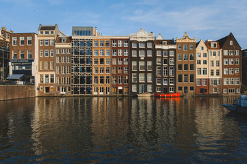 Fototapeta na wymiar Canal houses in Amsterdam during sunset with calm reflection in the water