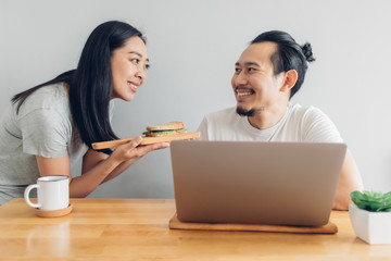 Asian wife is taking care of her husband in concept work from home.