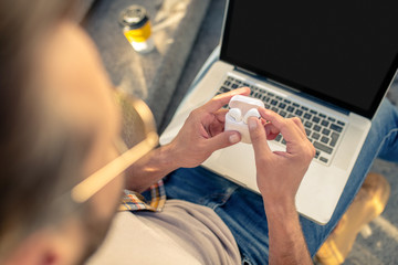 Fototapeta premium Man with open laptop and wireless headphones in case