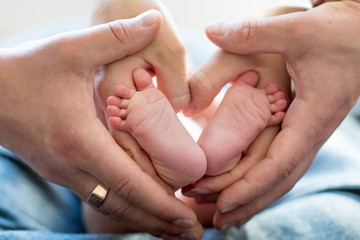 Obraz na płótnie Canvas favorite feet of the baby in parental hands