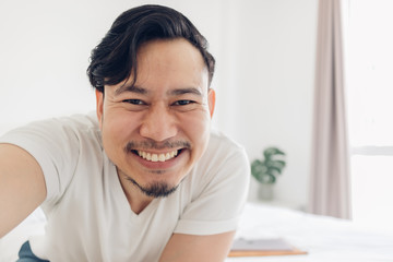 Fototapeta na wymiar Innocences smile of happy Asian man take selfie photo of himself.