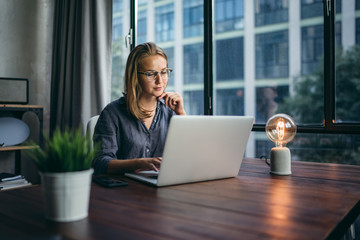 Young woman working with a laptop. Female freelancer connecting to internet via computer....