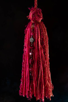 Borla colgante cortina color crudo de cintas de hilo de lana y piedras y joyas con fondo negro