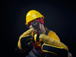 Fototapeta premium a guy in overalls and a construction helmet with a wrench