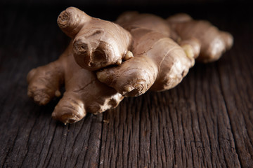 selective focus of ginger root on wooden background 