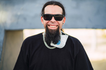 Chico joven con perilla y mascarilla en skate park