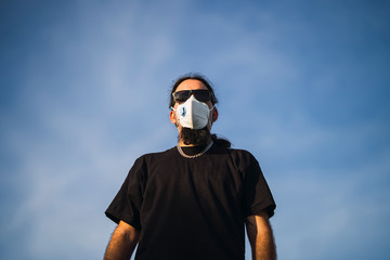 Chico joven con perilla y mascarilla en skate park
