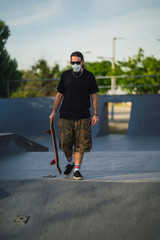 Chico joven con perilla y mascarilla en skate park