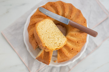 Fresh vanilla bundt cake on a wooden cutting board