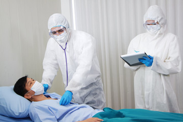 Medical team in Personal Protective Equipment or PPE clothing and Researching and Discussing Check up by Stethoscope for patients infected with the Covid 19 virus and treatment in hospital of Thailand