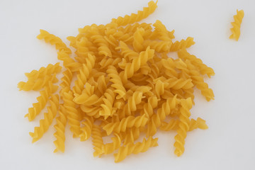 Shallow focus close up of spiral pasta over white background