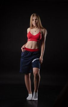 athletic girl in Boxing shorts on a black background