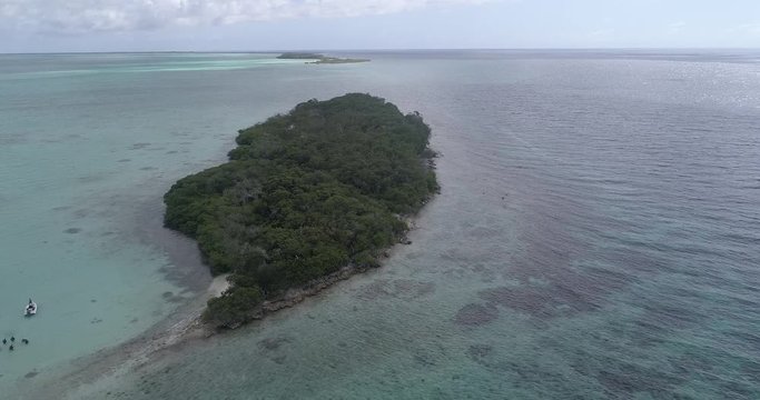 Landscape Maseta Cote island with boat, divers, blue water, Green mangrove in Los Roques National Park Venezuela Caribbean Sea. Aerial view drone 4k
