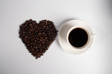 Black coffee and heart-shaped coffee beans