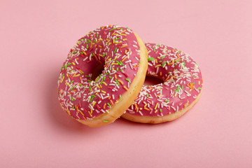 Tasty donut on patel pink background.