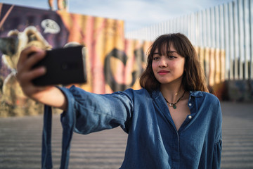 Chica joven en un skate park haciendose selfies