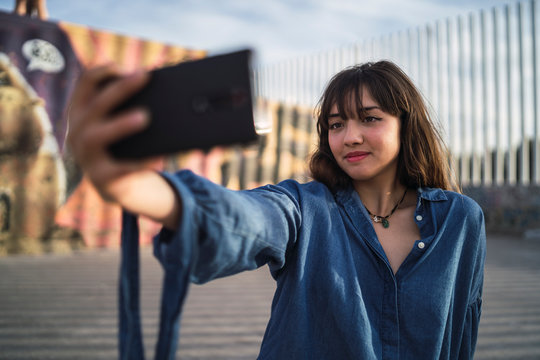 Chica joven en un skate park haciendose selfies
