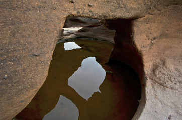 Clear water pond with sky chimney reflection in small cave