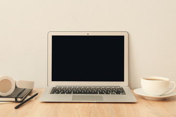 Fototapeta premium Laptop with stationery and cup of coffee at workplace