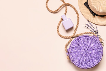 Straw hat and bag with perfume bottle on light background
