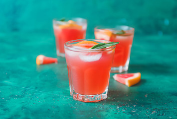 Glass of fresh grapefruit juice on color background