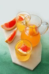 Fresh grapefruit juice on color background