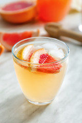 Glass of fresh grapefruit juice on table