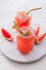 Mason jars of fresh grapefruit juice on table