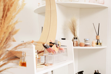 Table with mirror and decorative cosmetics in modern makeup room
