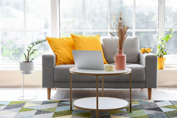 Stylish interior of living room with comfortable sofa and table