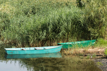 Fototapeta na wymiar Old boats standing by the river Bank