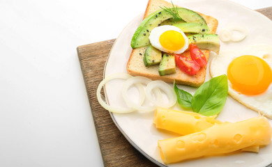 Plate with tasty avocado sandwich, fried egg and cheese on white background