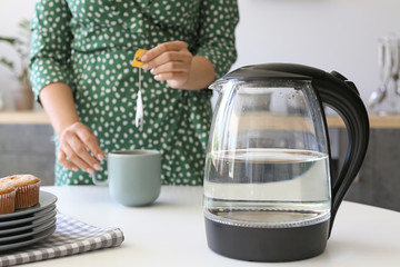 Woman making tea in kitchen